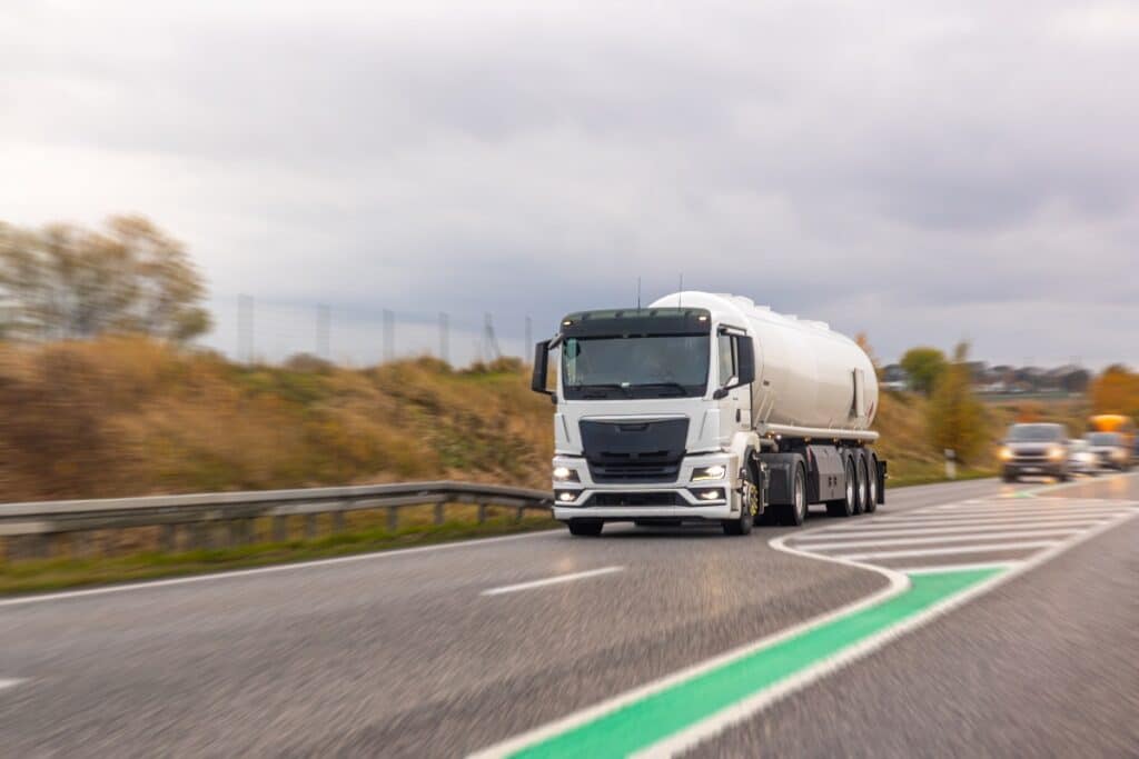 A truck with a cistern rushing on the road.