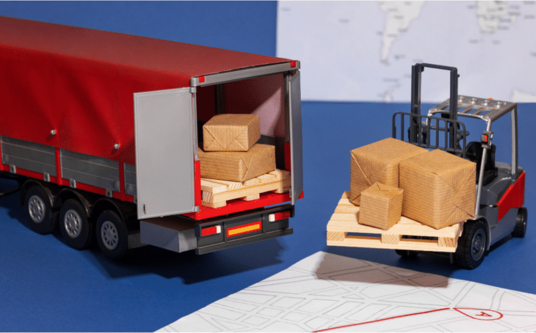 Miniature freight truck and forklift transporting cargo boxes on pallets.